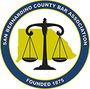 Logo of the San Bernardino County Bar Association, featuring a black scale of justice over a yellow county map.