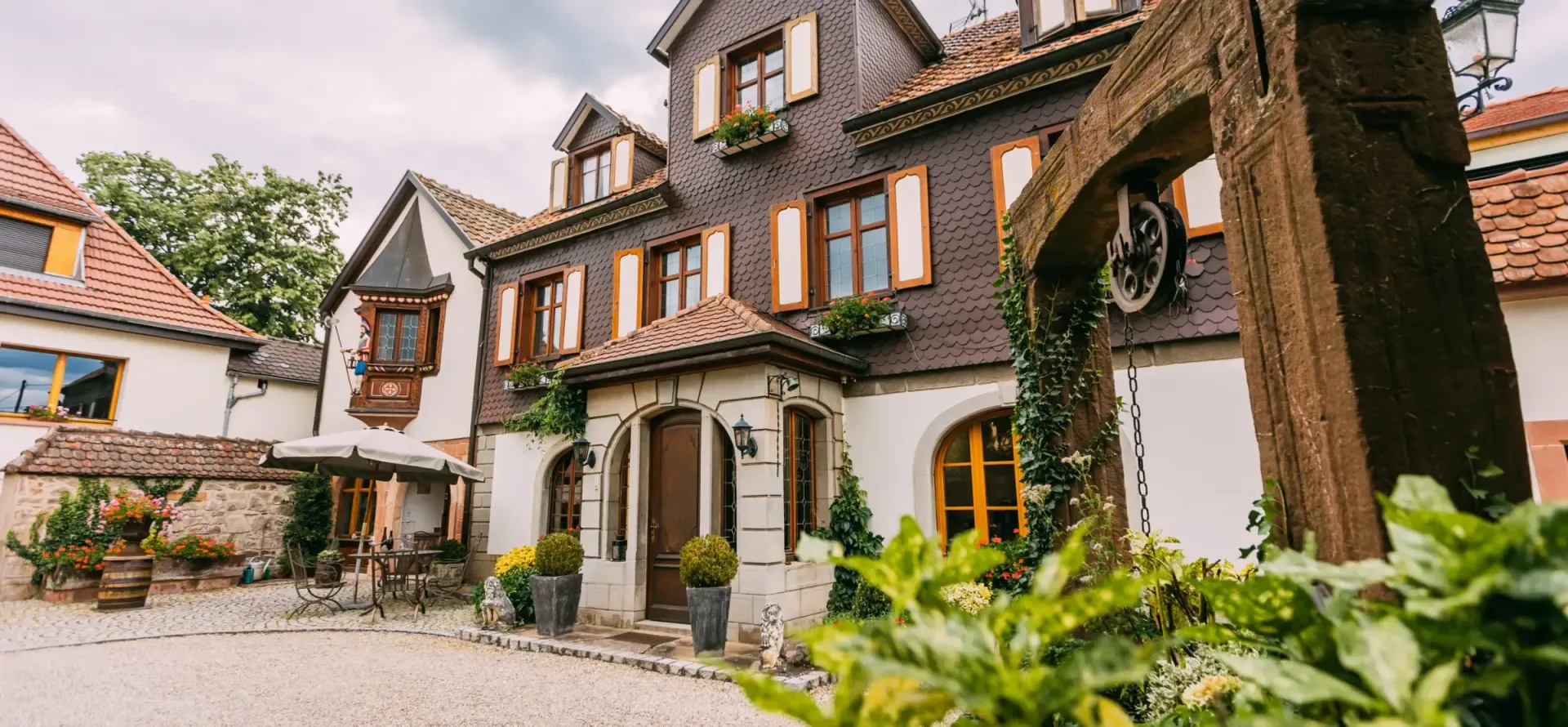 Un grand bâtiment en briques avec une arche en bois devant lui.