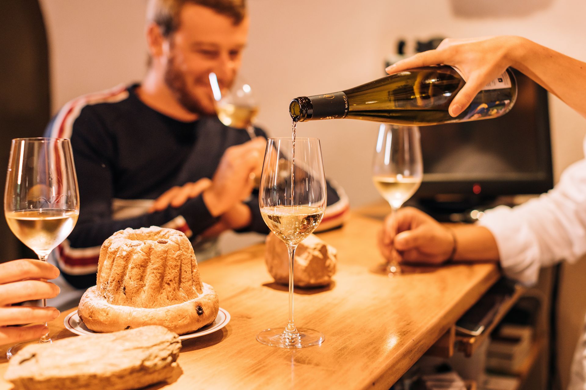 Une femme verse du vin dans un verre à une table.
