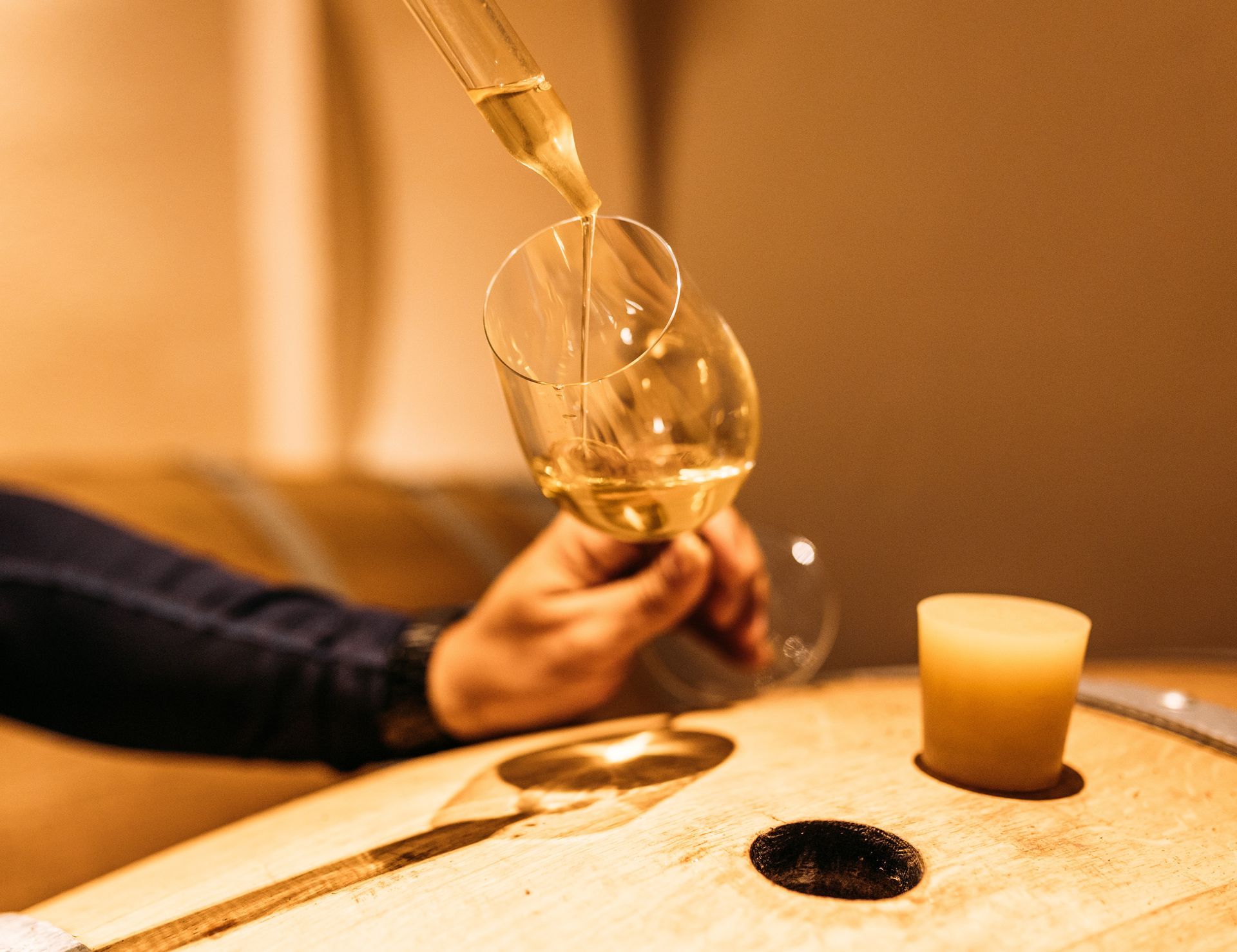 Une personne verse du vin dans un verre sur une table.