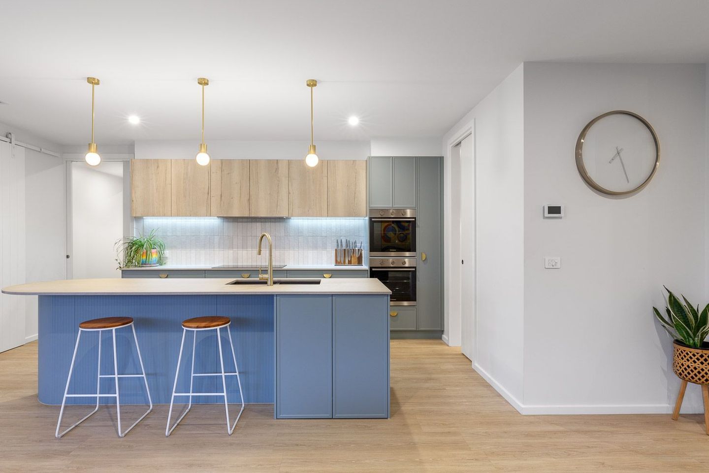 Modern Kitchen With Blue Island, Two Stools, Pendant Lights, and Wood Flooring — Jetsonian Constructions In Wendouree, VIC