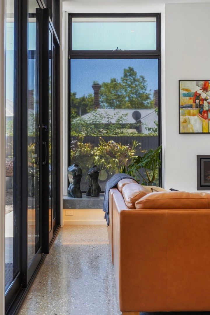 Modern Living Room With Orange Sofa Facing Tall Windows and a View of Trees Outside — Jetsonian Constructions In Wendouree, VIC