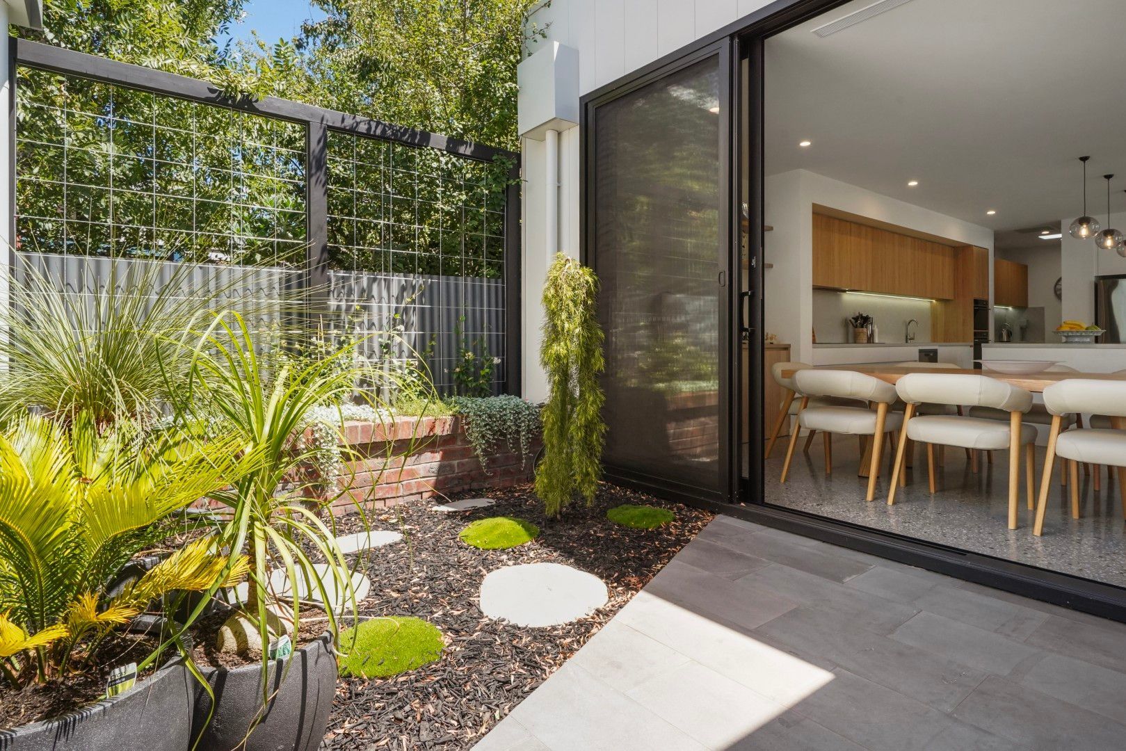 Modern Patio With Potted Plants, Stepping Stones, and an Open Sliding Door to a Bright Kitchen — Jetsonian Constructions In Wendouree, VIC
