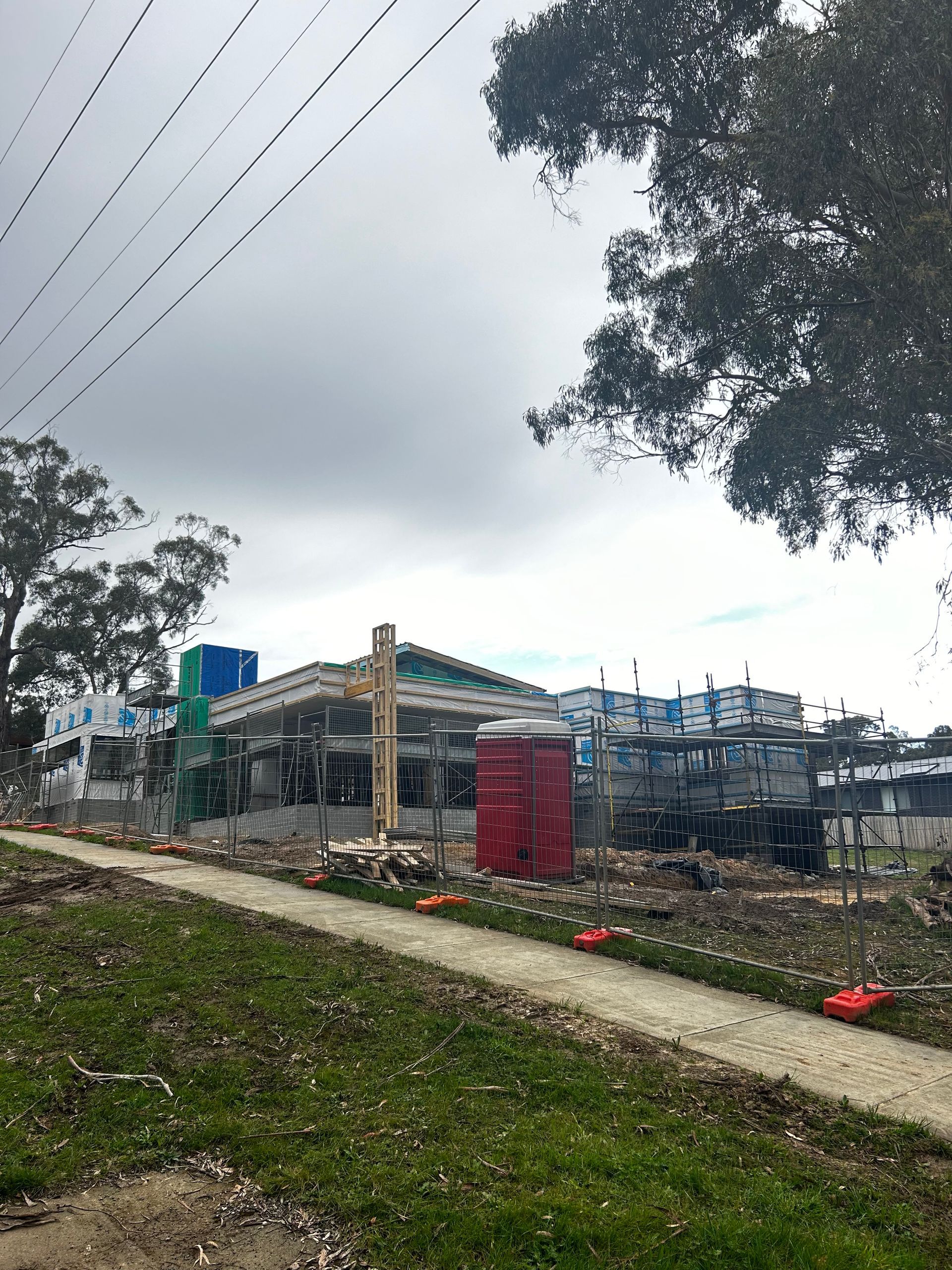 Partly Built Outdoor Structure With Scaffolding and Red Tarp Beside a Grassy Path Under a Cloudy Sky — Jetsonian Constructions In Wendouree, VIC