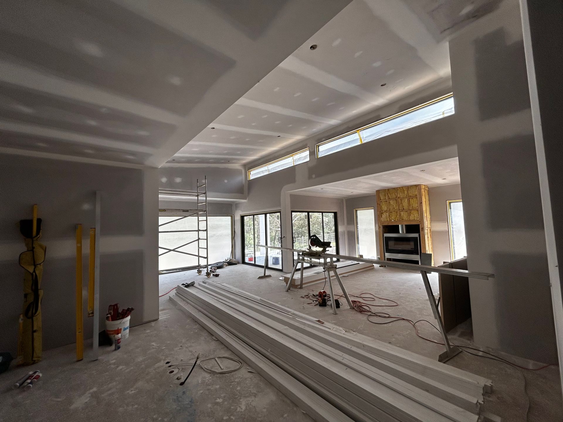 Renovated Interior With Exposed Beams, Stacked Boards, and Tools on a Dusty Floor Near Large Windows — Jetsonian Constructions In Wendouree, VIC
