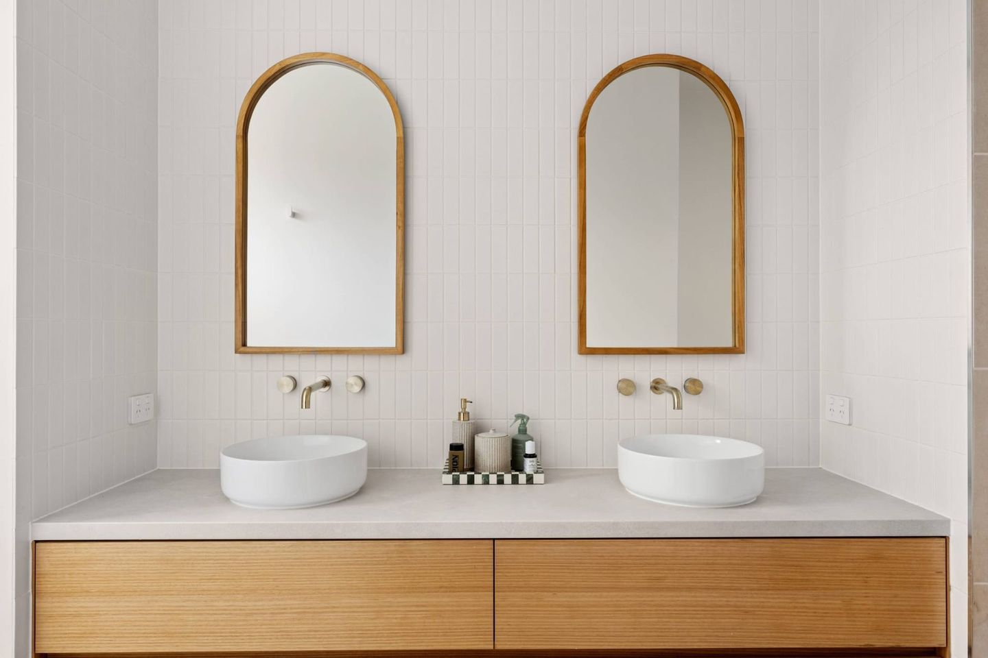 Modern Double-sink Bathroom Vanity With Wood Cabinets, Round Basins, and Arched Mirrors Against a Light Wall — Jetsonian Constructions In Wendouree, VIC