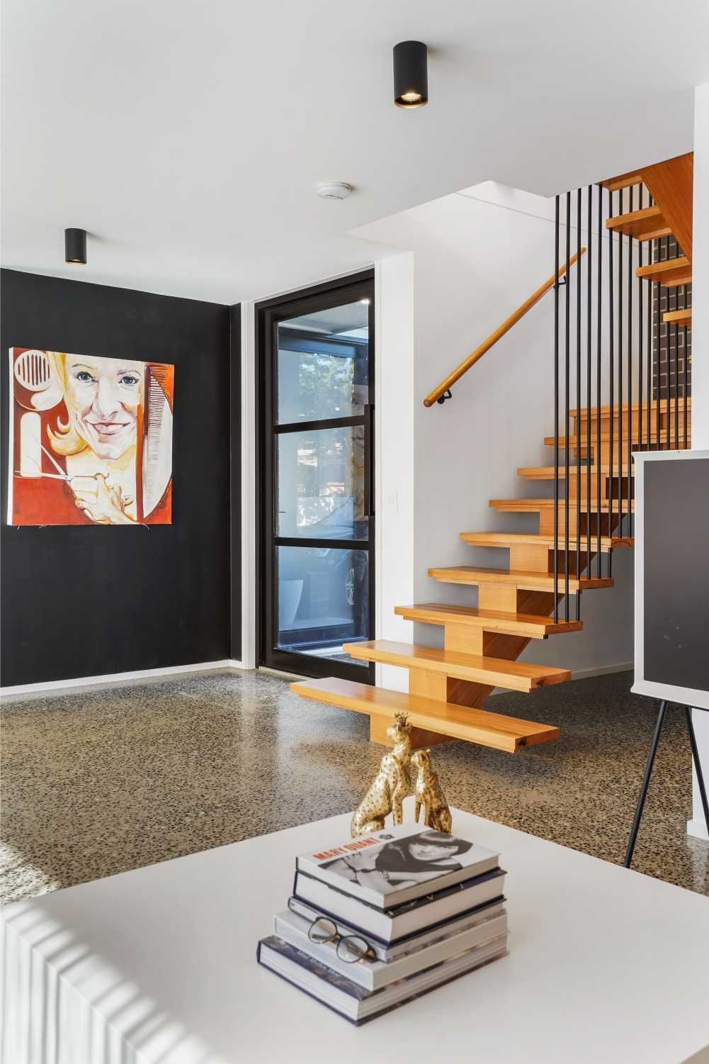 A Living Room With A Wooden Staircase And A Stack Of Books On A Table — Jetsonian Constructions In Wendouree, VIC