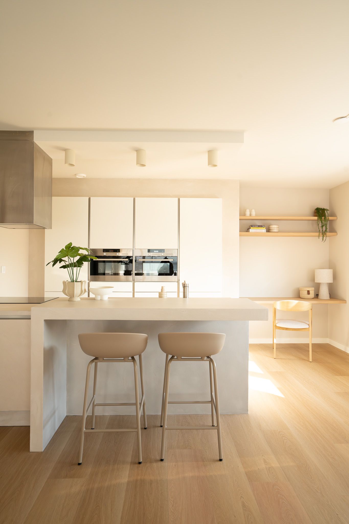 Drie interieurs in neutrale tinten. Keuken, woonkamer met salontafel en vaas, eetkamer met ronde tafel.