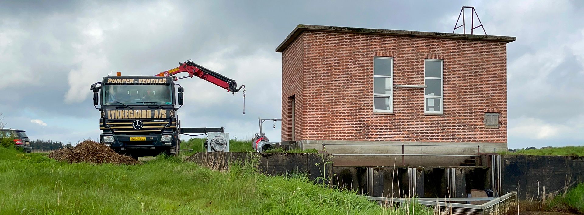 Lastbil fra Lykkegaard foran pumpehus i forbindelse med montage af ny pumpe