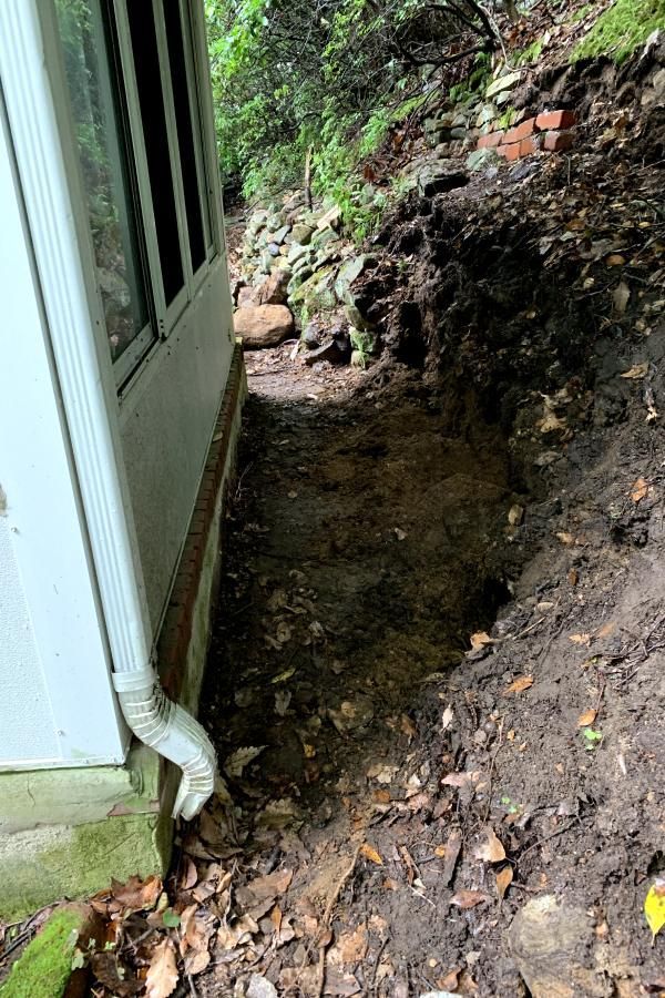There is a hole in the ground next to a house.