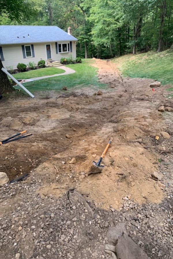 A pile of dirt and rocks in front of a house.