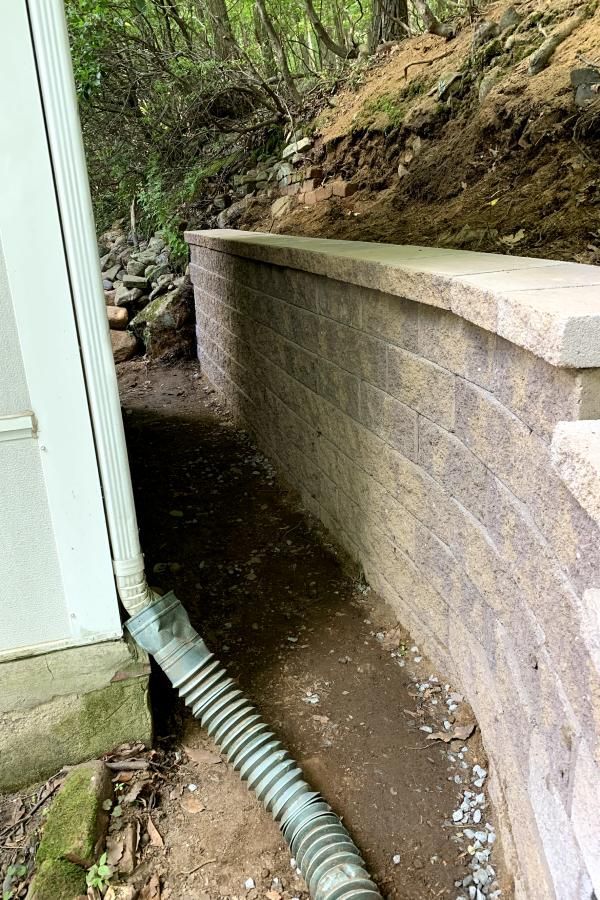A hose is connected to a brick wall next to a house.