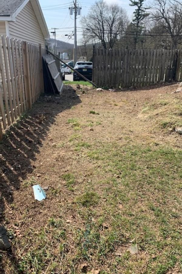 There is a wooden fence in the backyard of a house.