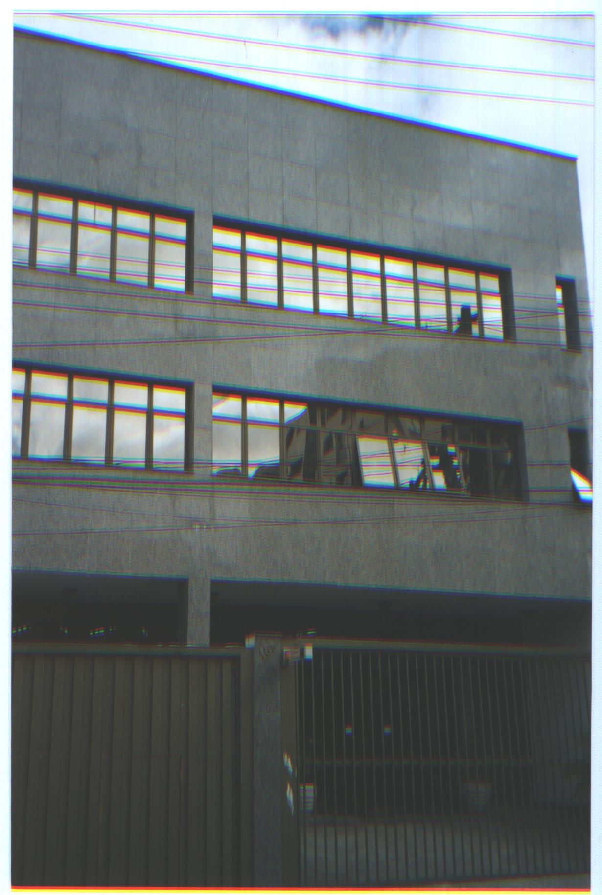 Um grande edifício com muitas janelas e uma cerca na frente