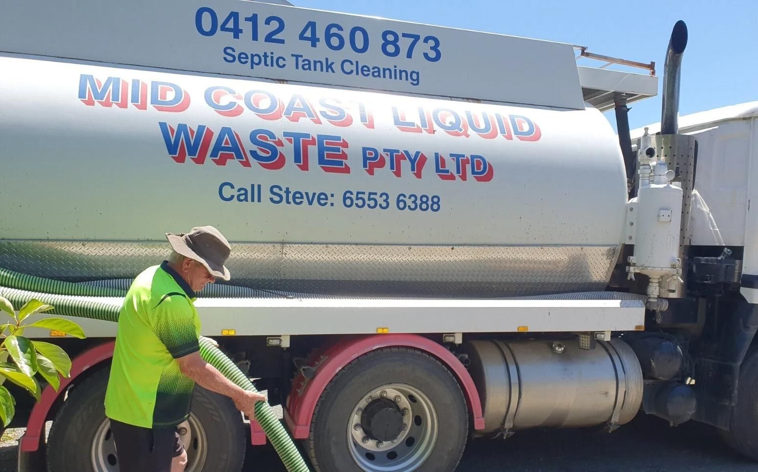 A Man is Pumping Water From a Truck That Says Mid Coast Liquid Waste Pty Ltd — Mid Coast Liquid Waste In Rainbow Flat, NSW