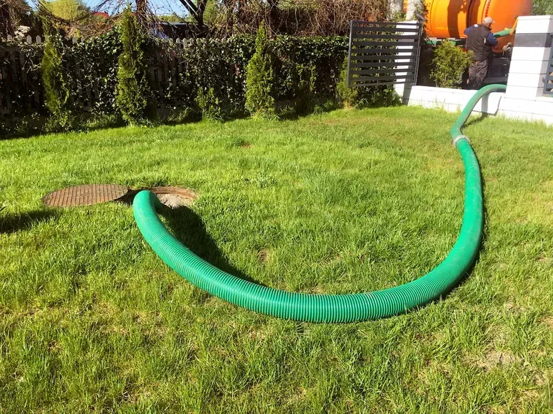 A Green Hose is Sitting on Top of a Lush Green Lawn — Mid Coast Liquid Waste In Wauchope, NSW