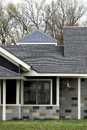 Exterior of a house with a gray roof and a mix of gray and tan brick walls.