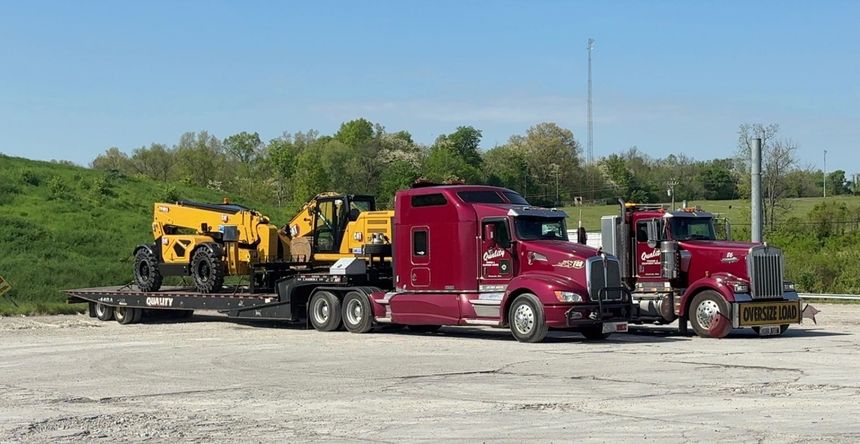Semi truck transporting excavator on flatbed trailer for heavy equipment hauling. Semi truck transporting excavator on flatbed trailer for heavy equipment hauling.