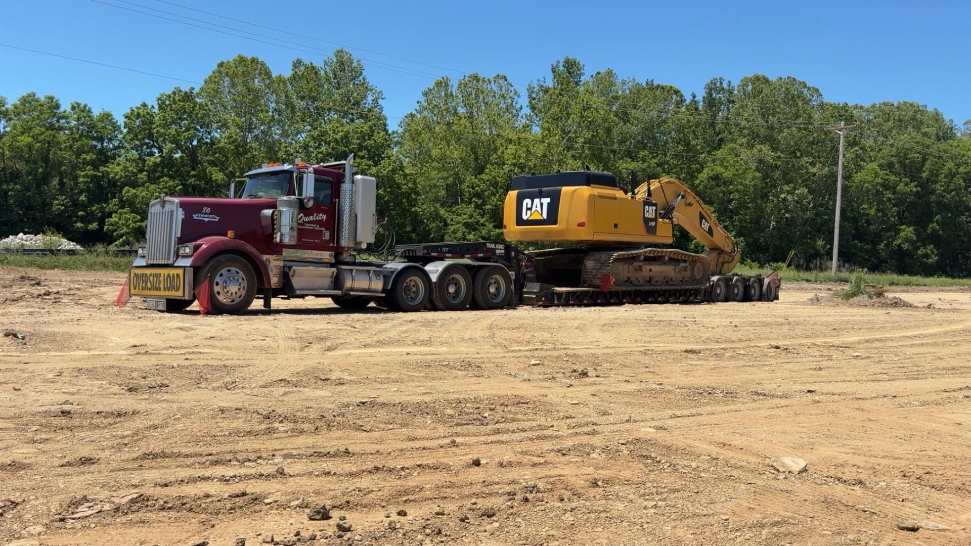 Quality Towing truck hauling a yellow excavator
