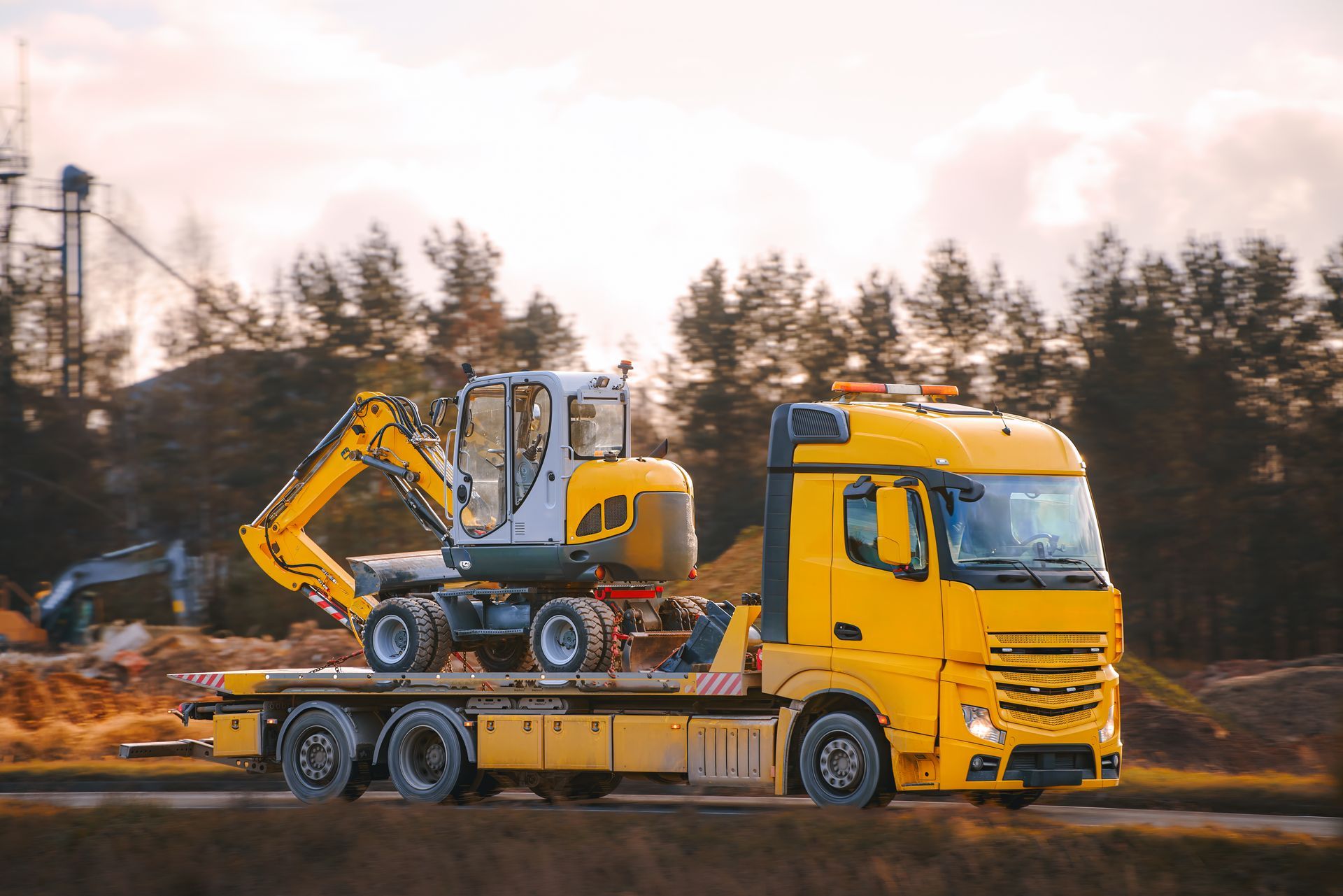 Heavy equipment being moved by trailer truck