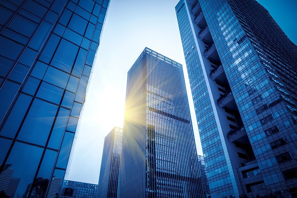 the sun is shining through the windows of the skyscrapers