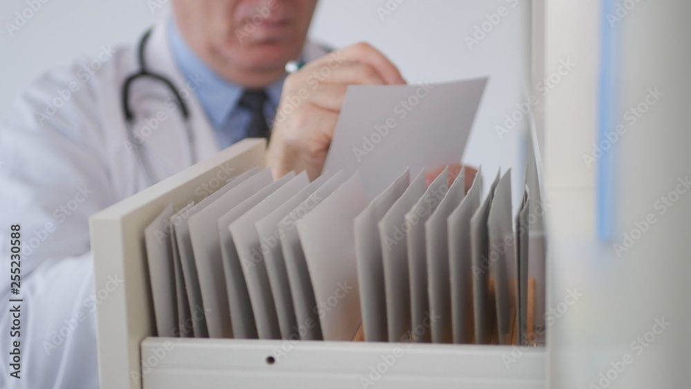 a doctor is looking through a drawer full of medical records