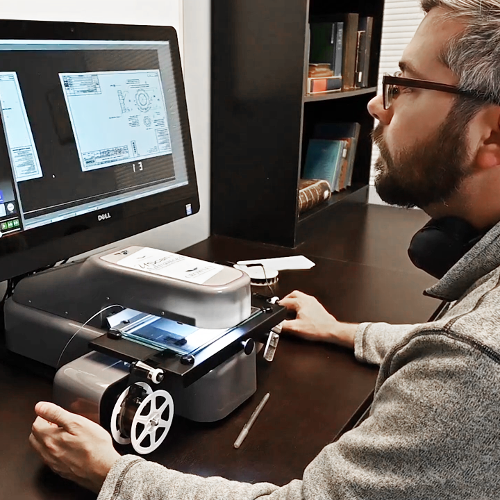 a man using microfilm scanning equipment