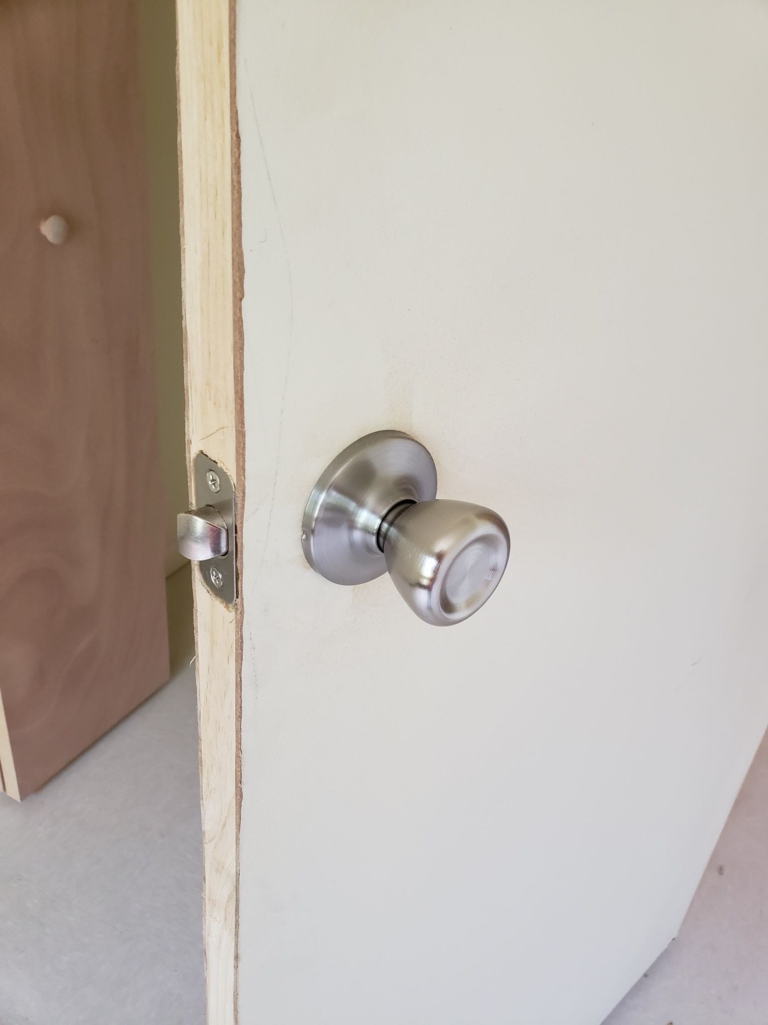 A close up of a door knob on a white door.