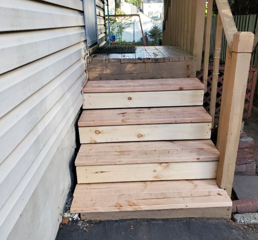 A set of wooden stairs next to a house