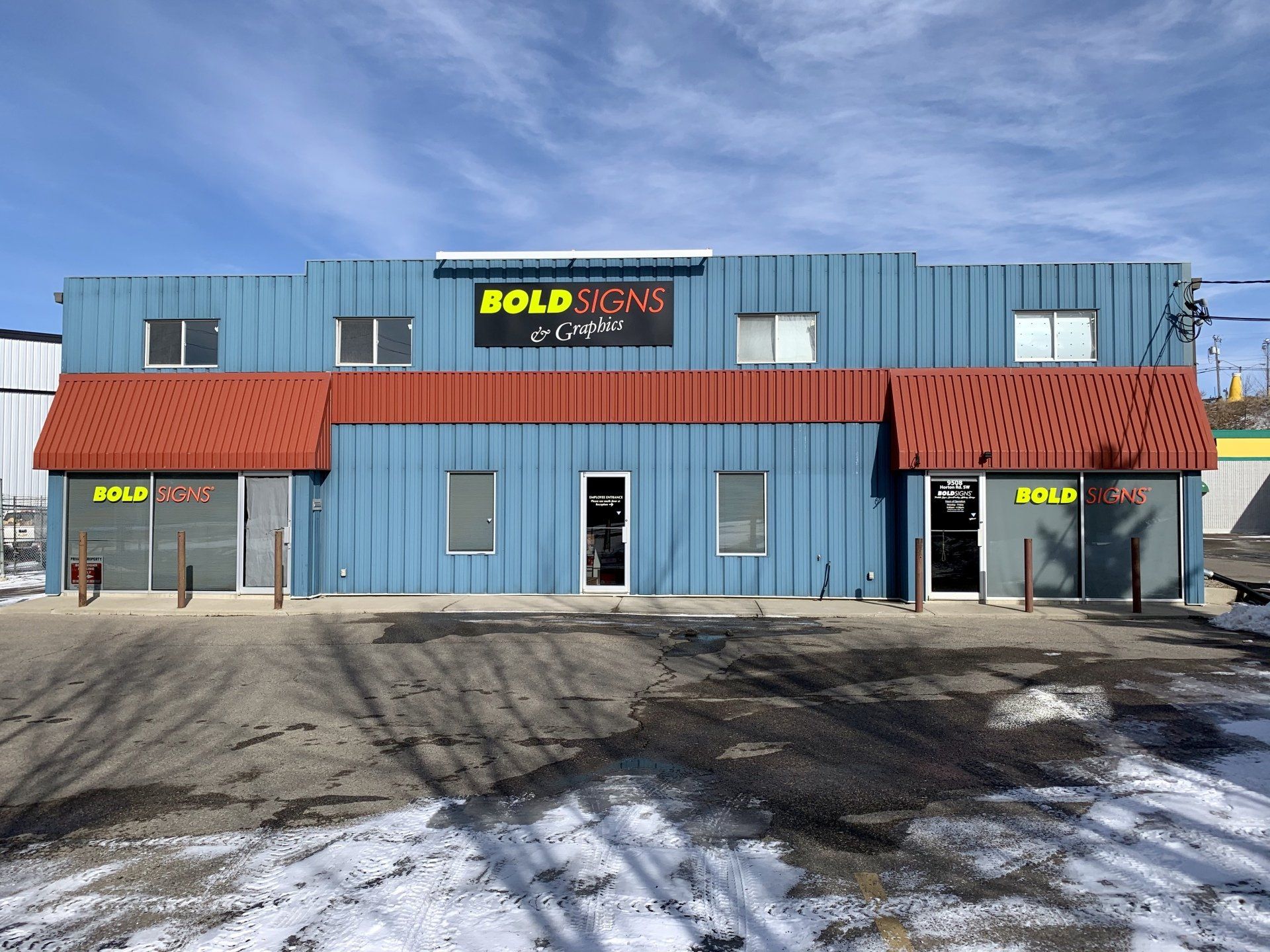 A blue building with a red awning and a sign that says bold signs
