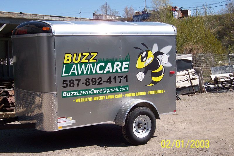 A trailer with buzz lawncare written on it