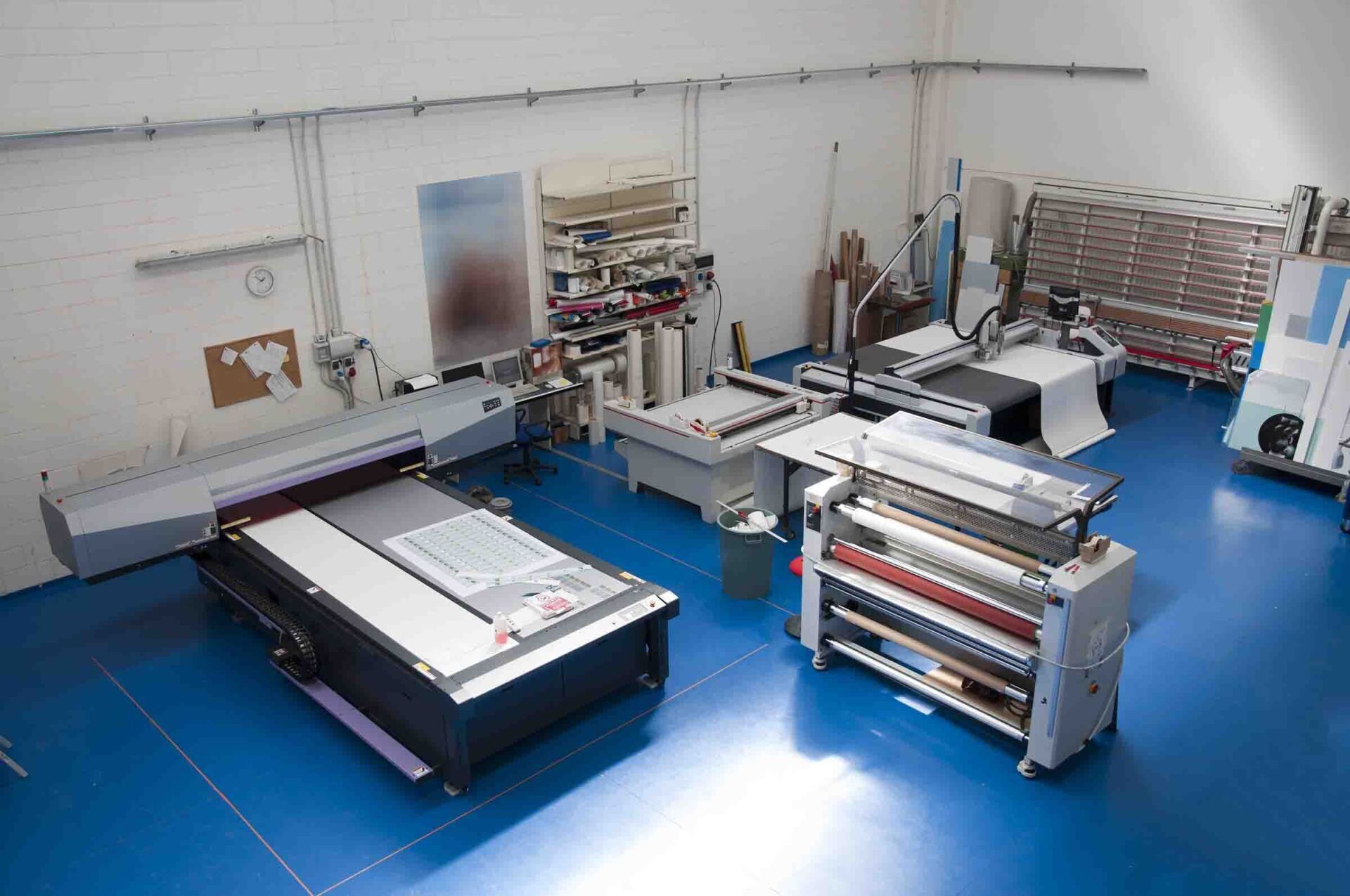 A large room with a blue floor and lots of machinery.