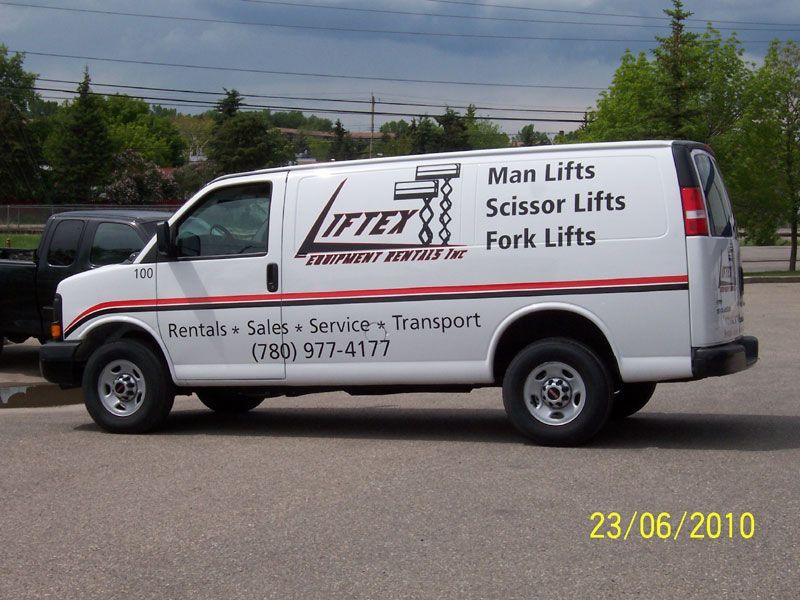 A white liftex van is parked in a parking lot