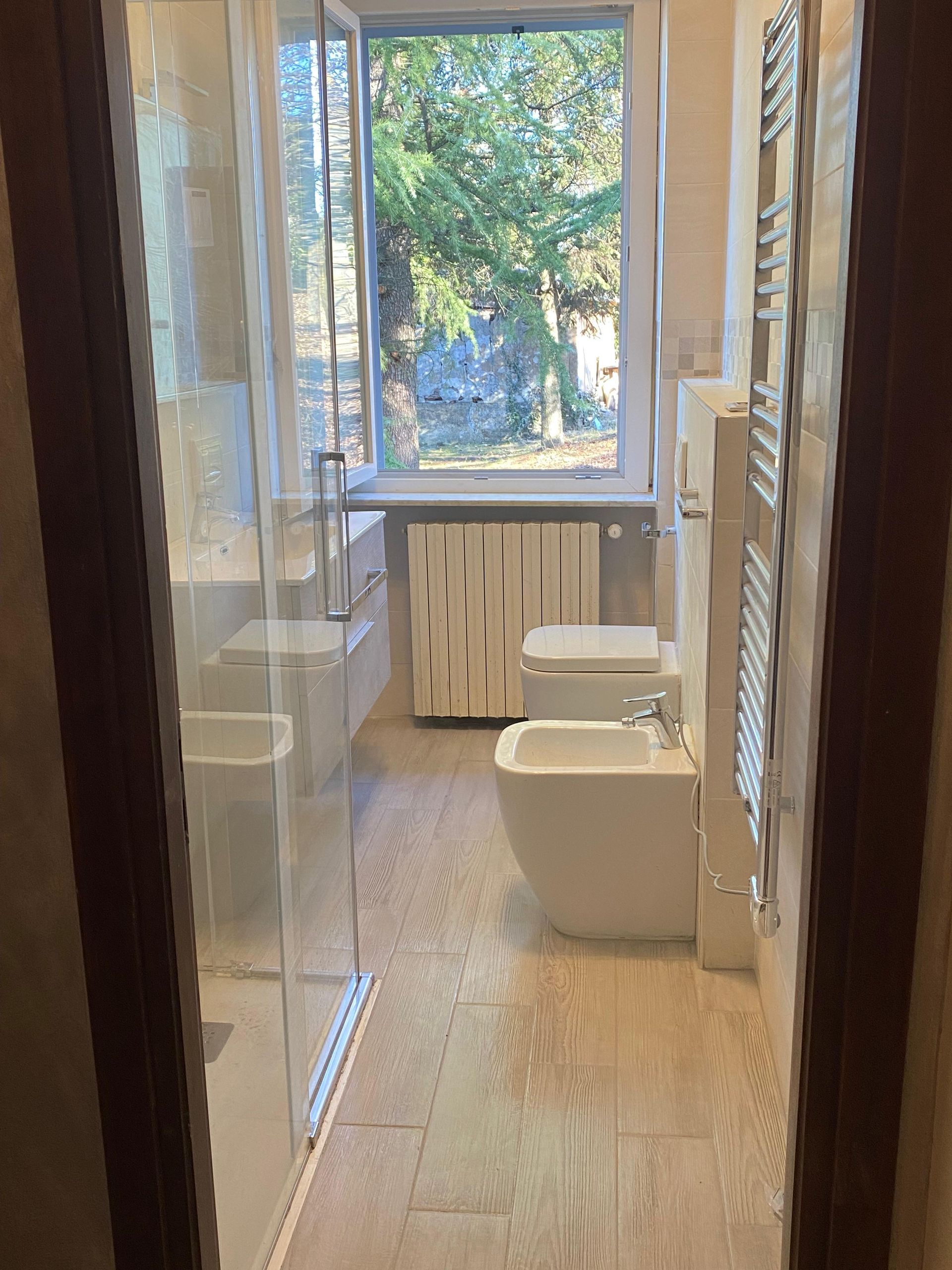 Un bagno con due water, un bidet e una finestra.