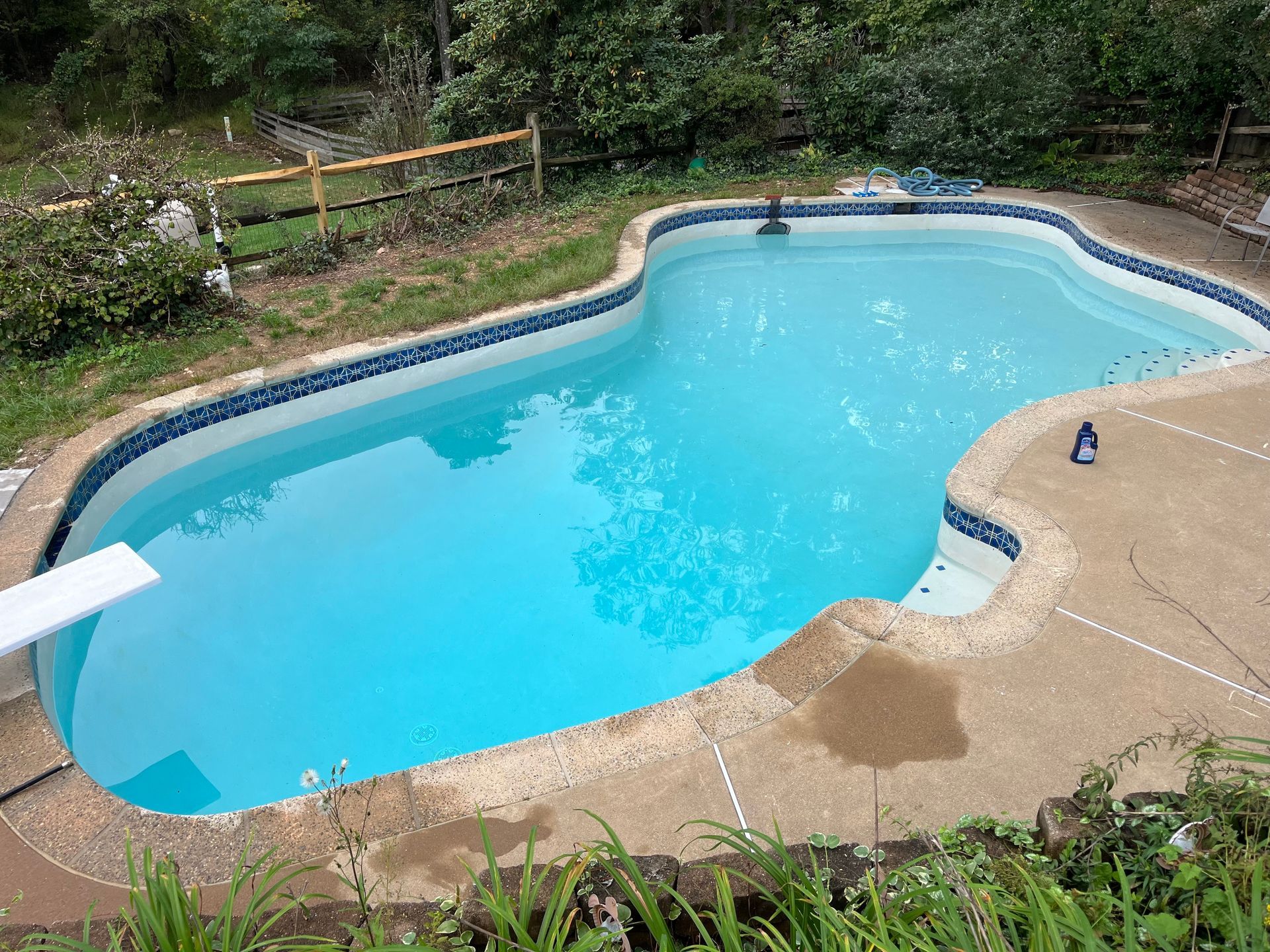 Pool equipment enclosure, featuring a blue filter, black pipes, pump, and chemical containers.