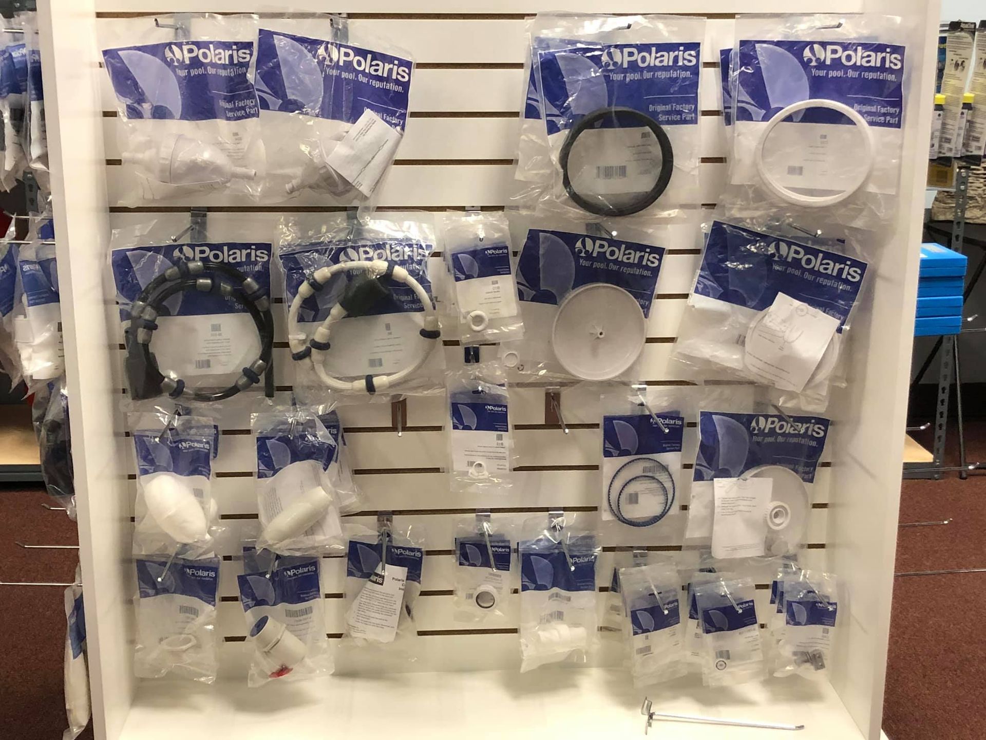 Wall display of packaged Polaris pool cleaner parts.