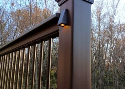 A close up of a wooden railing with a light on it.