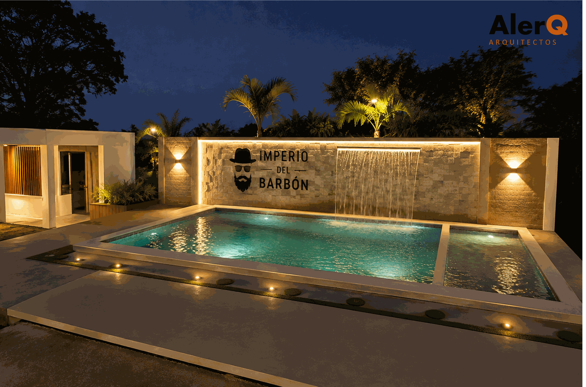 Patio con piscina por la noche, con luces cálidas, muros de piedra y un letrero iluminado junto al agua.