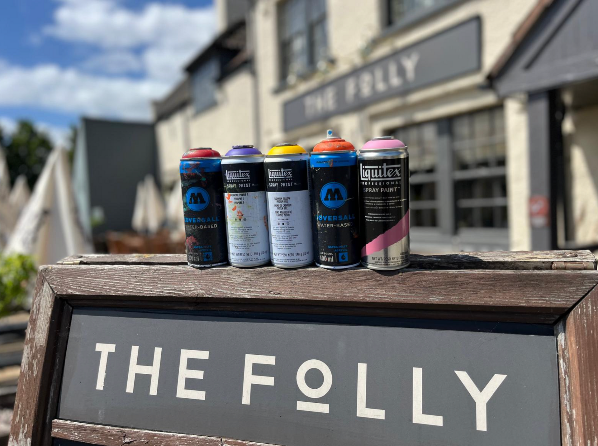 The Folly Pub sign with spray cans on top
