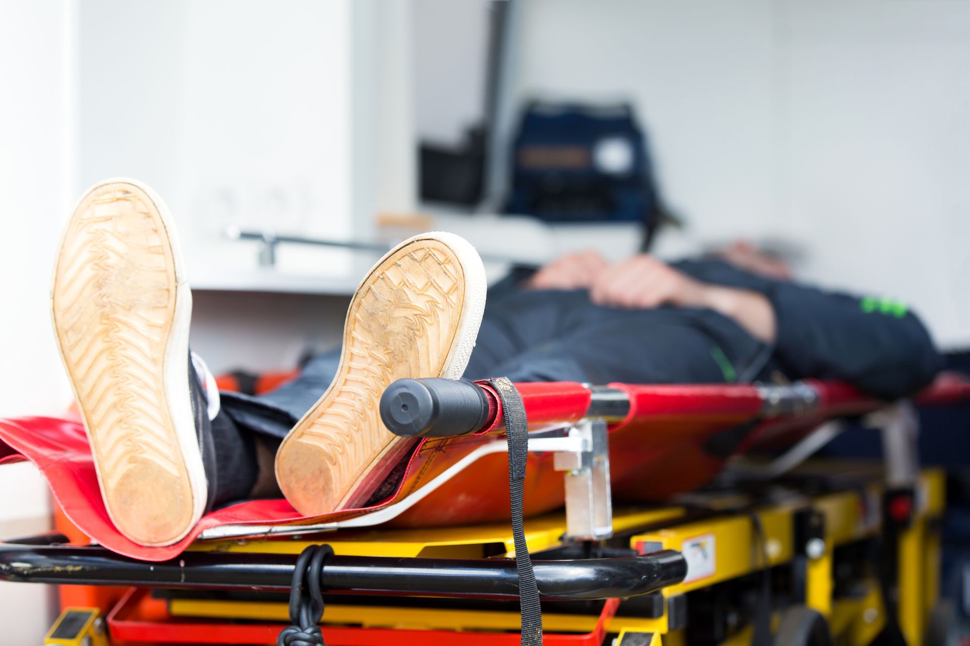 Patient lying on a stretcher with legs extended in a medical transport setting