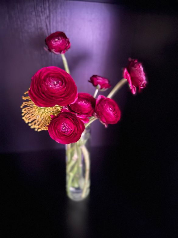 A bunch of flowers are sitting on a table next to a lamp.