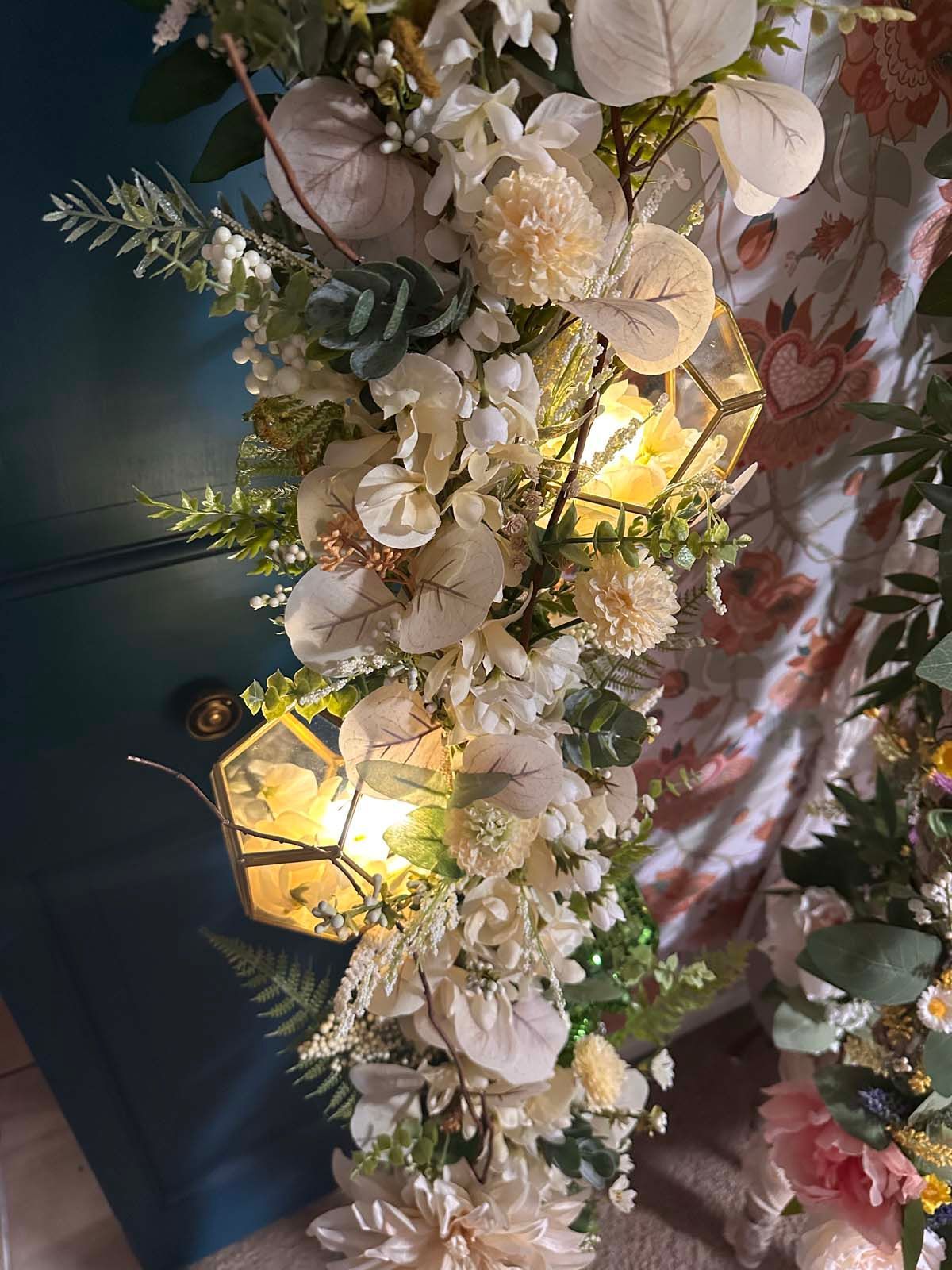 A bunch of flowers are sitting on a table next to a lamp.