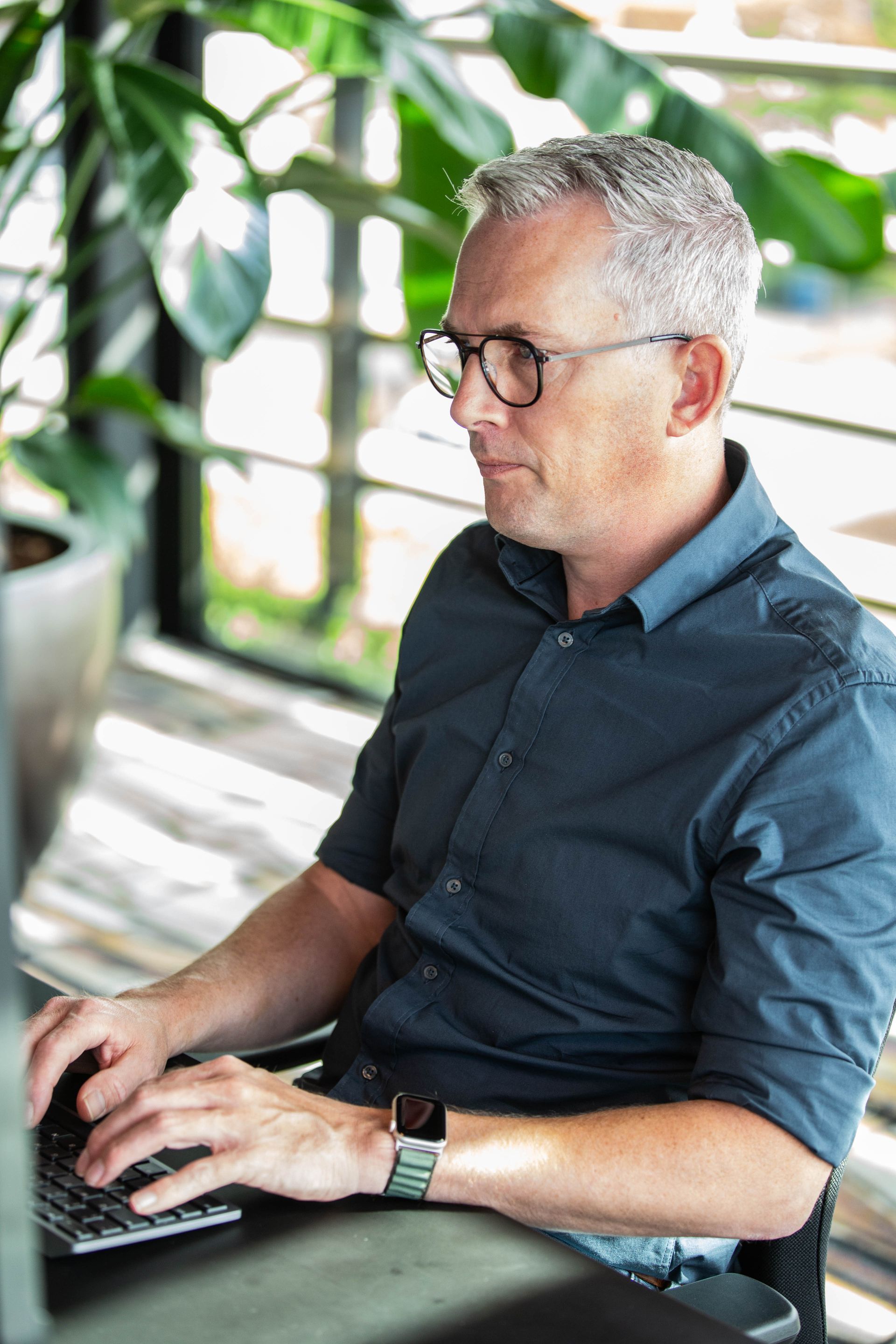 Collega met serieuze blik aan het werk