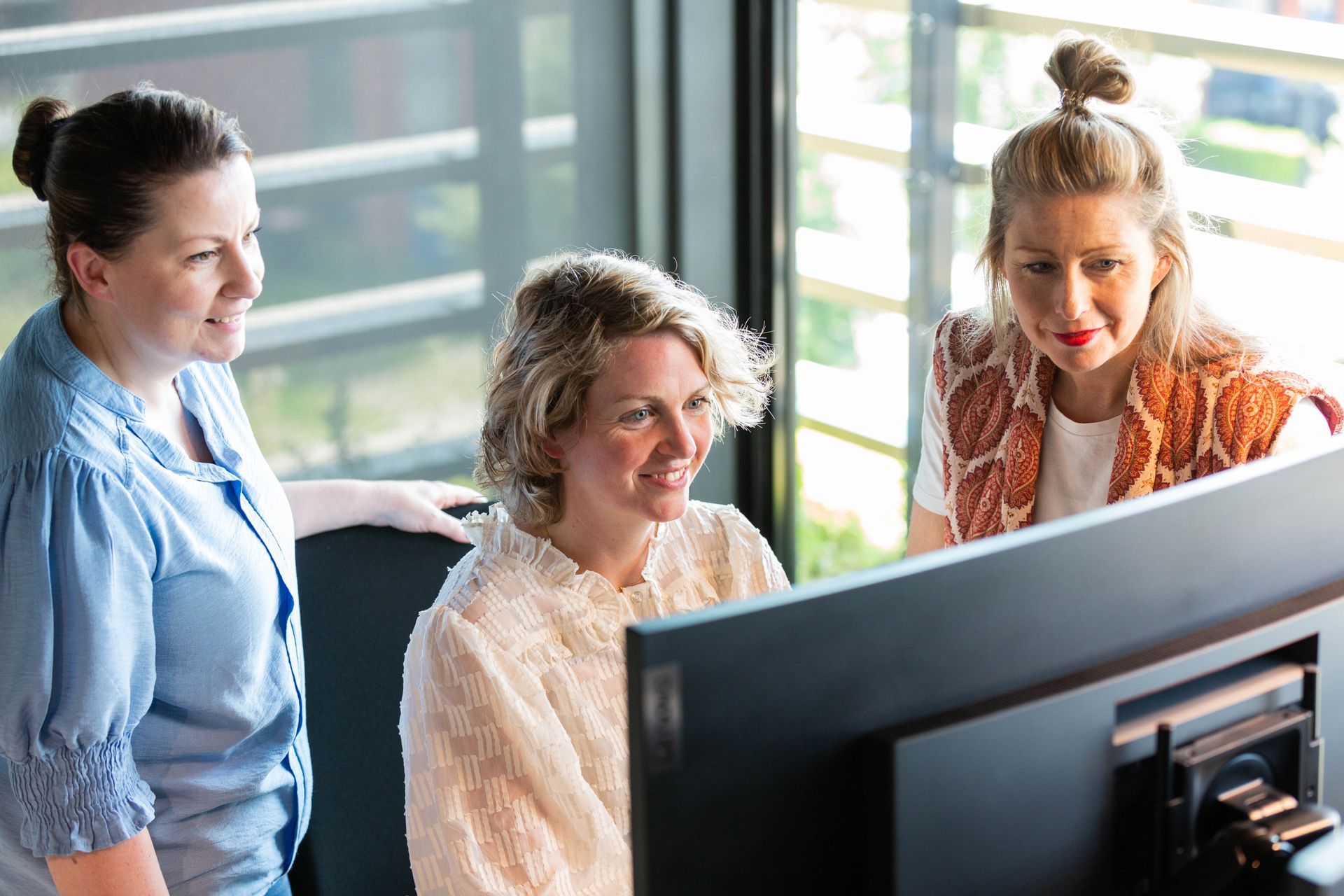 Drie collega's samenwerken achter 1 beeldscherm