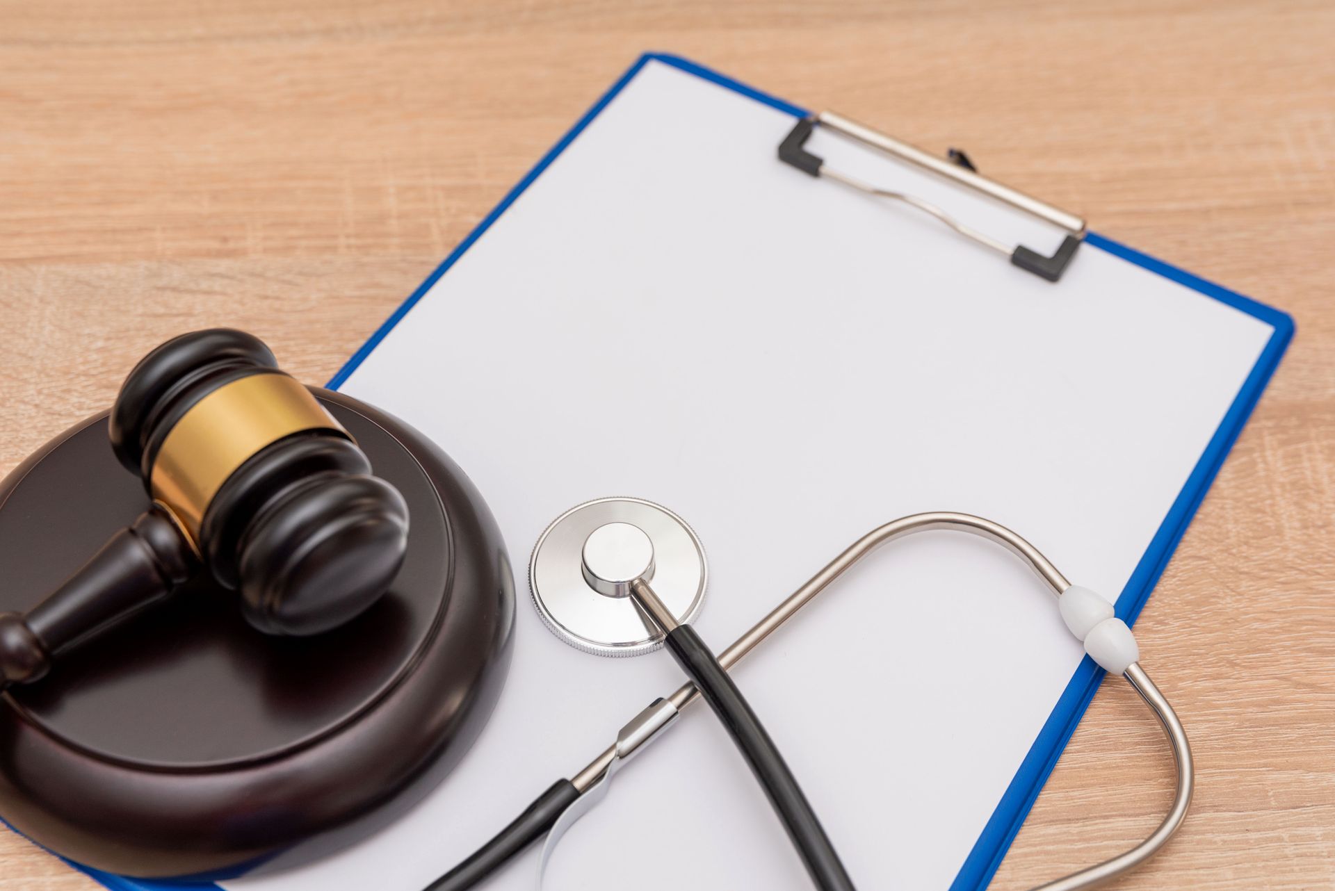 Gavel and stethoscope resting on a clipboard, symbolizing healthcare-related legal matters.