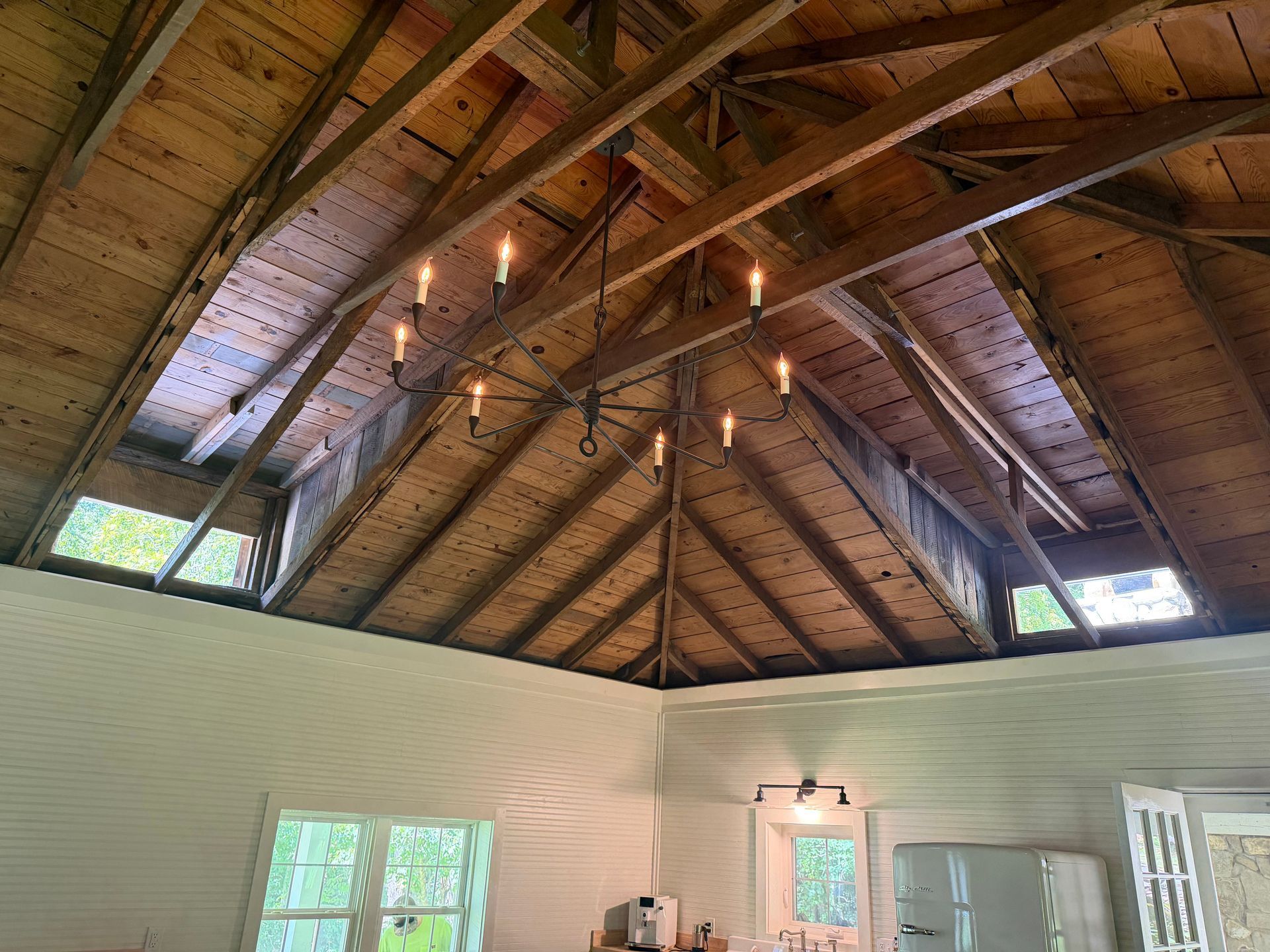 Vaulted wood ceiling with exposed beams over a bright white interior room.