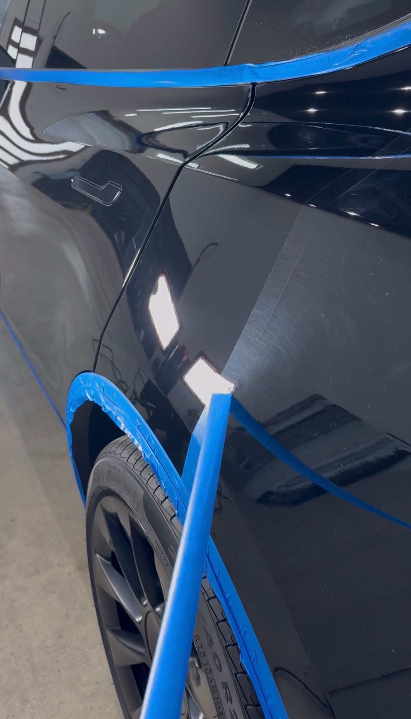 A black tesla before and after paint correction.
