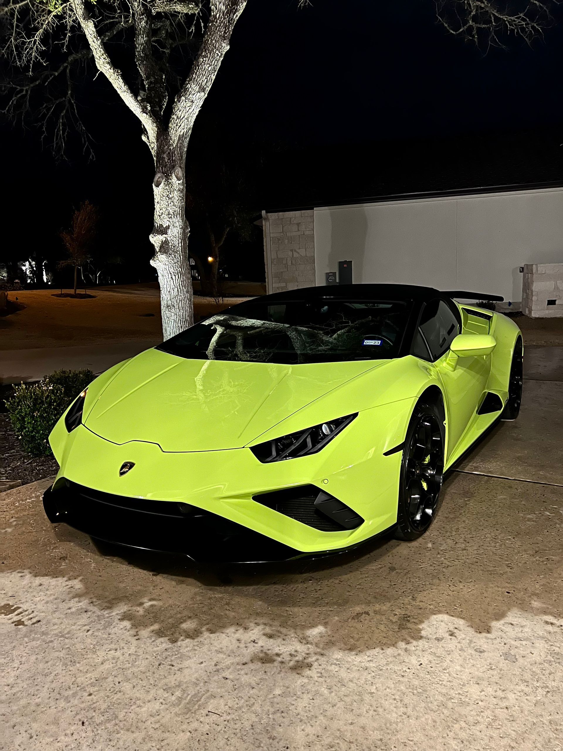Neon green Lamborghini convertible parked at night.