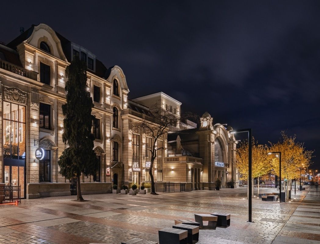 A row of buildings are lit up at night in a city.