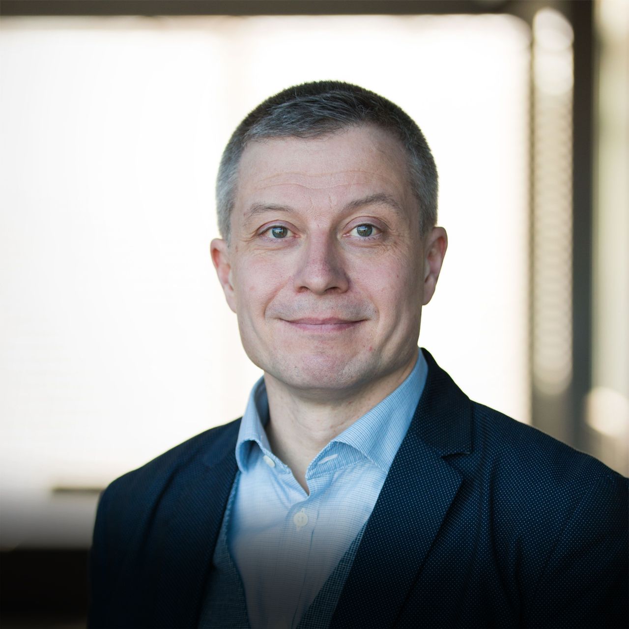 A man in a suit is smiling for the camera